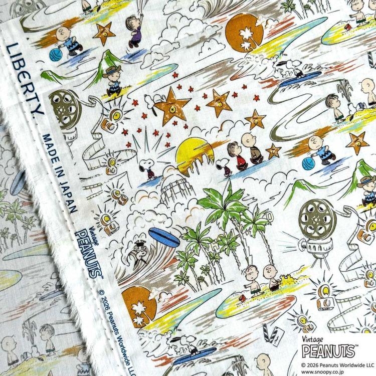 The image is a vibrant and colorful fabric print featuring various cartoon characters and scenes, including Peanuts characters, such as Charlie Brown, Snoopy, and Woodstock. The print is a collage of multiple images, creating a lively and dynamic visual experience.