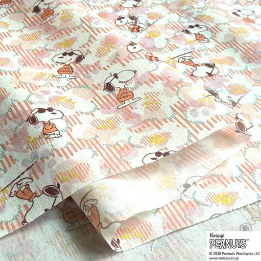 a close-up view of a fabric with a repeating pattern of cartoon characters, specifically the Peanuts characters.