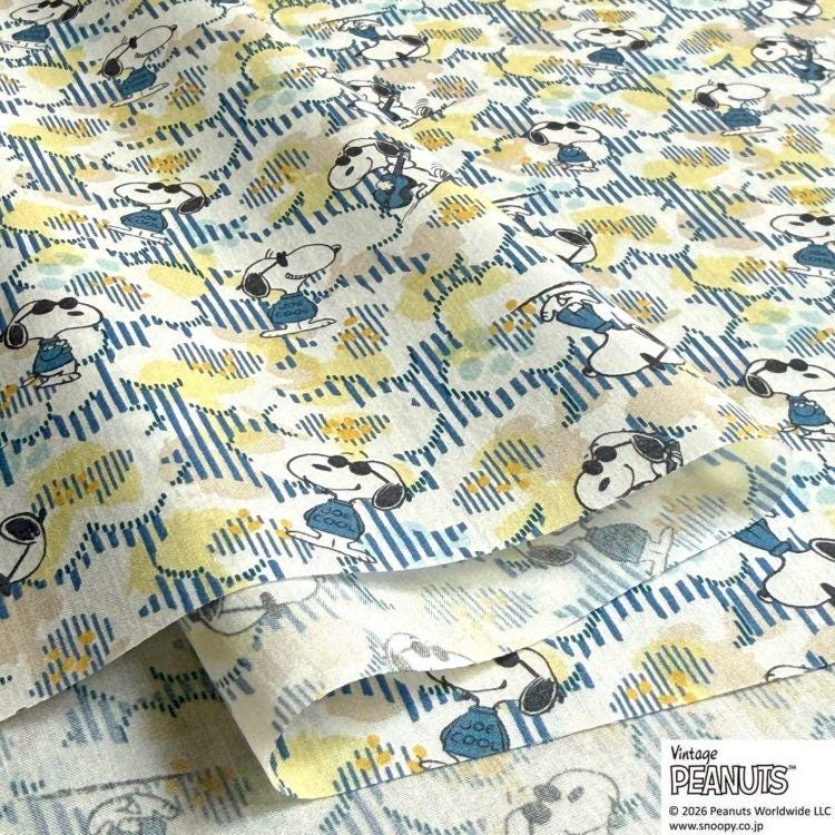 a close-up view of a fabric with a repeating pattern of cartoon characters, specifically the Peanuts characters. The pattern consists of various Peanuts characters in different poses and expressions, creating a lively and playful visual. The fabric appears to be a piece of clothing or textile, with the repeating pattern adding a sense of texture and depth to the image.