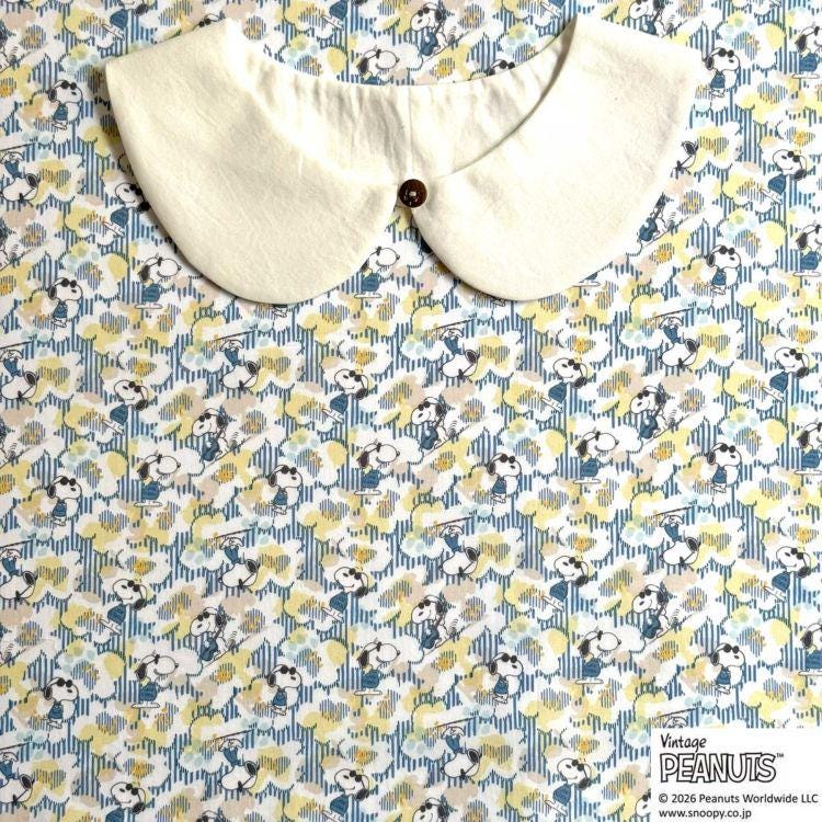 A white collar is displayed on a fabric with a repeating pattern of cartoon characters, specifically the Peanuts characters.