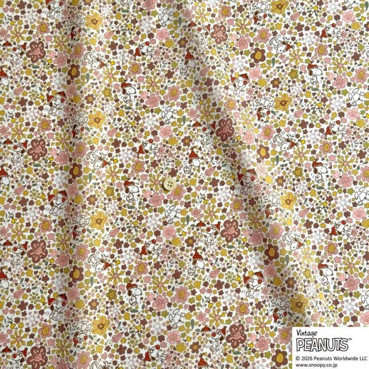 The image is a close-up of a fabric with a floral pattern, featuring a button in the center.