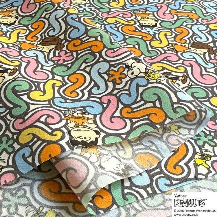 a vibrant and colorful pattern with various cartoon characters and designs, including Peanuts characters, creating a lively and playful visual.