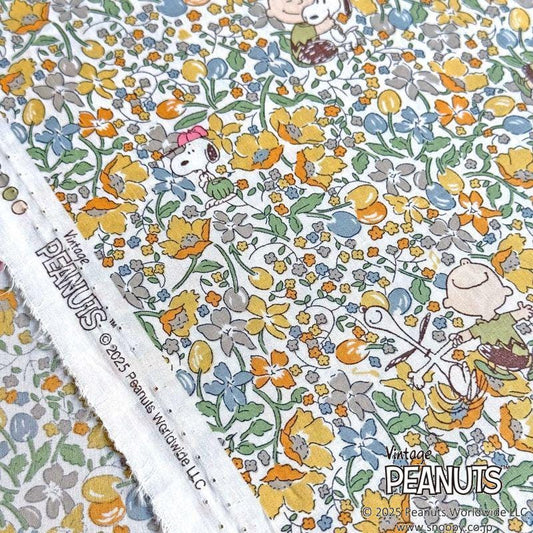 The image is a close-up of a fabric with a floral pattern featuring characters from the Peanuts comic strip.
