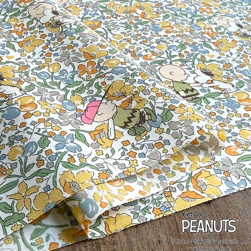 a close-up view of a fabric with a floral pattern and cartoon characters, including the Peanuts characters.