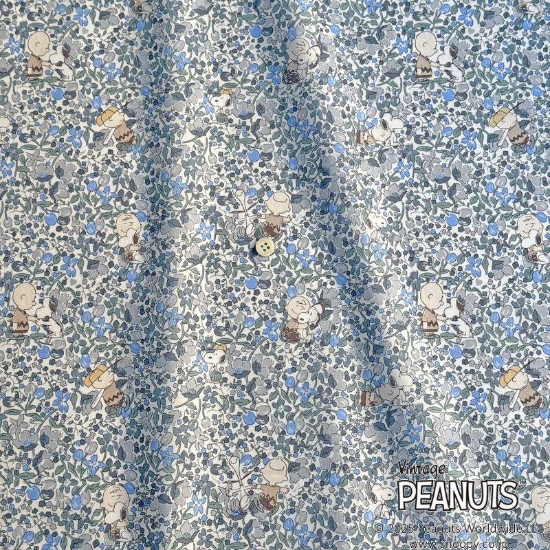 The image is a fabric with a repeating pattern of cartoon characters, specifically the Peanuts characters, printed in shades of blue and gray.