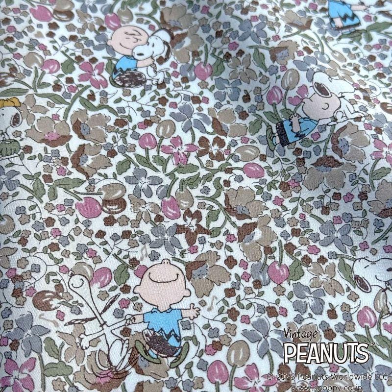 The image is a close-up of a fabric with a floral pattern featuring characters from the Peanuts comic strip.