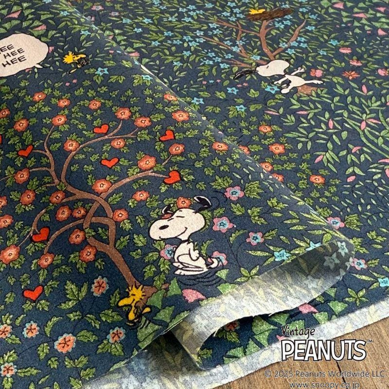 a close-up view of a fabric with a floral pattern and illustrations of characters from the Peanuts comic strip.