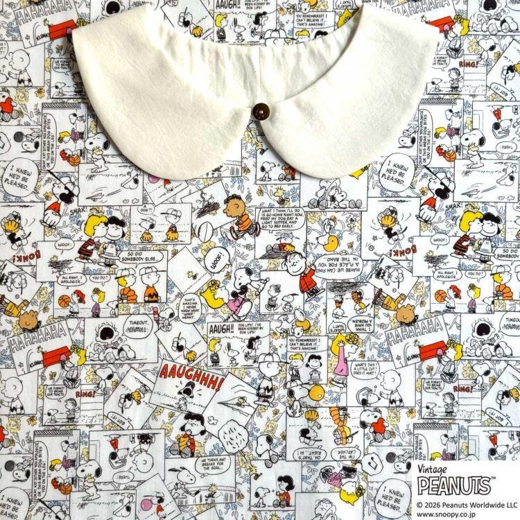 The image is a collage of various Peanuts comic strip panels, featuring characters such as Snoopy, Charlie Brown, and Peanuts. The collage is spread across a fabric surface, with a white collar visible in the top left corner.