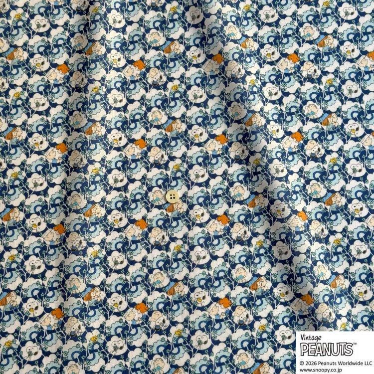 The image is a fabric with a repeating pattern of blue and white flowers, along with small orange and white objects. The pattern is intricate and detailed, creating a visually appealing design.