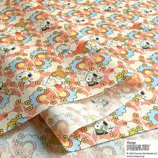 a close-up view of a fabric with a repeating pattern of cartoon characters, including Snoopy, Peanuts, and other iconic characters from the Peanuts comic strip.