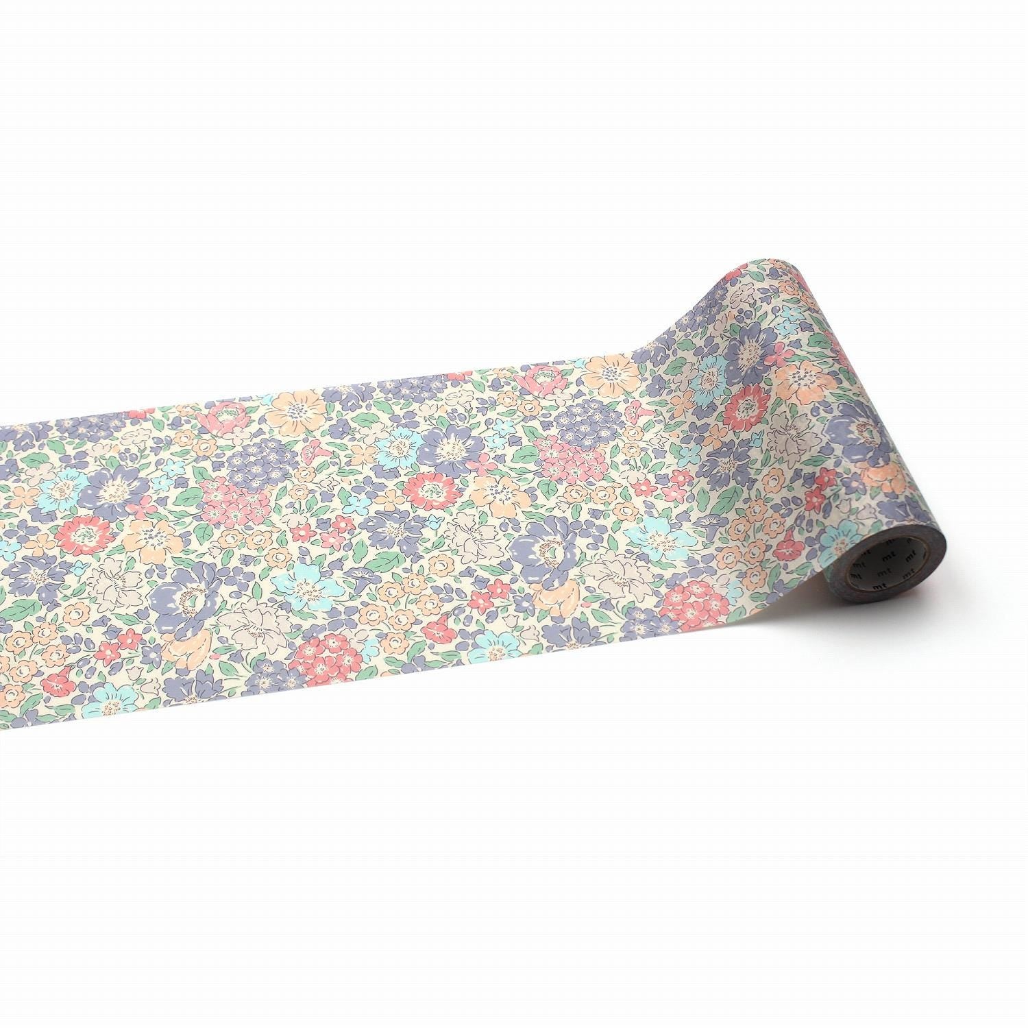 A roll of paper with a floral pattern on it, lying on a white background.
