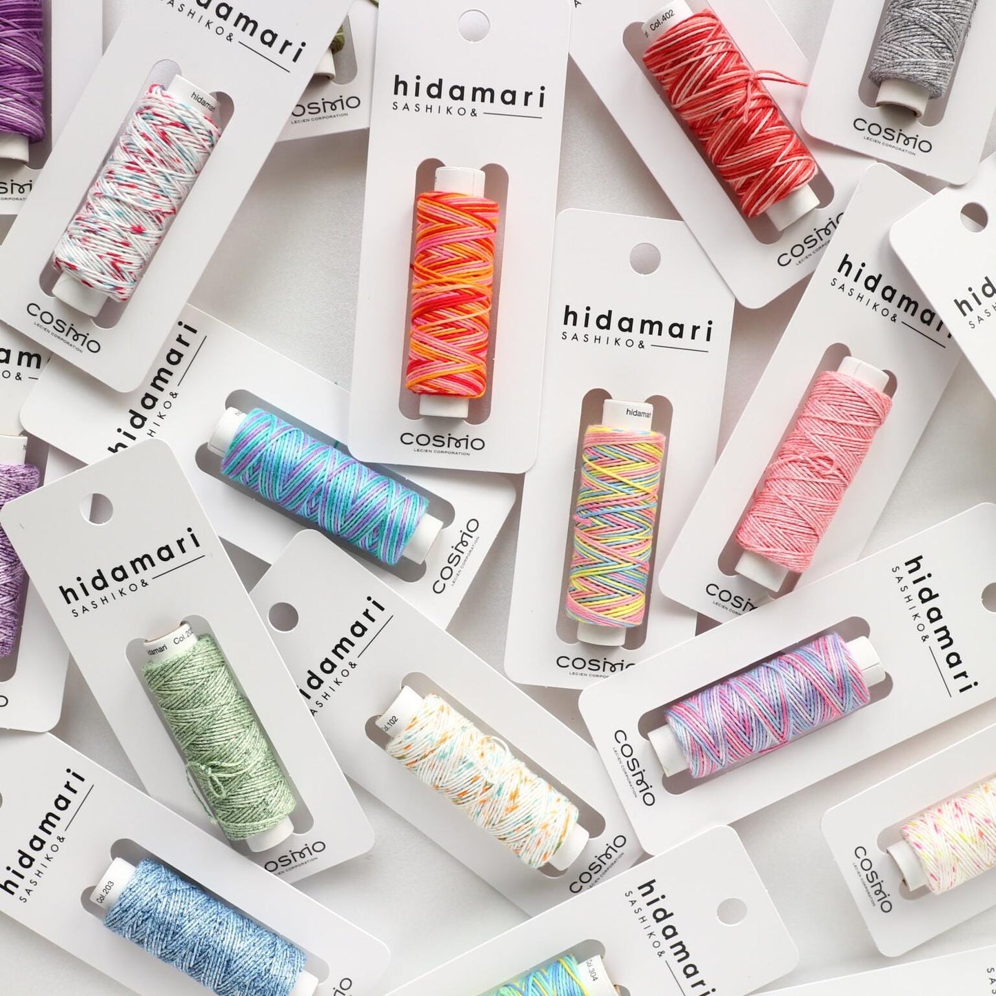 multiple packages of colorful spools of thread, each with a label that reads "kidamari" and "cosmo".