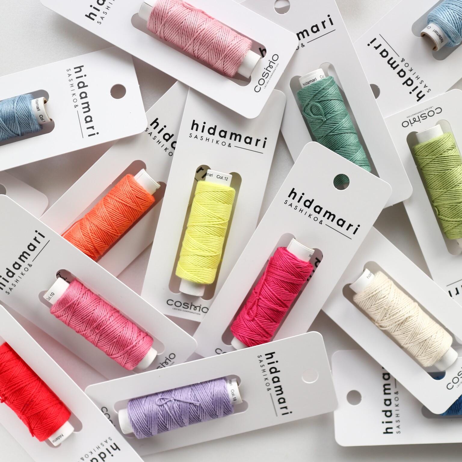 multiple packages of colorful thread or yarn, each with a spool of thread inside.