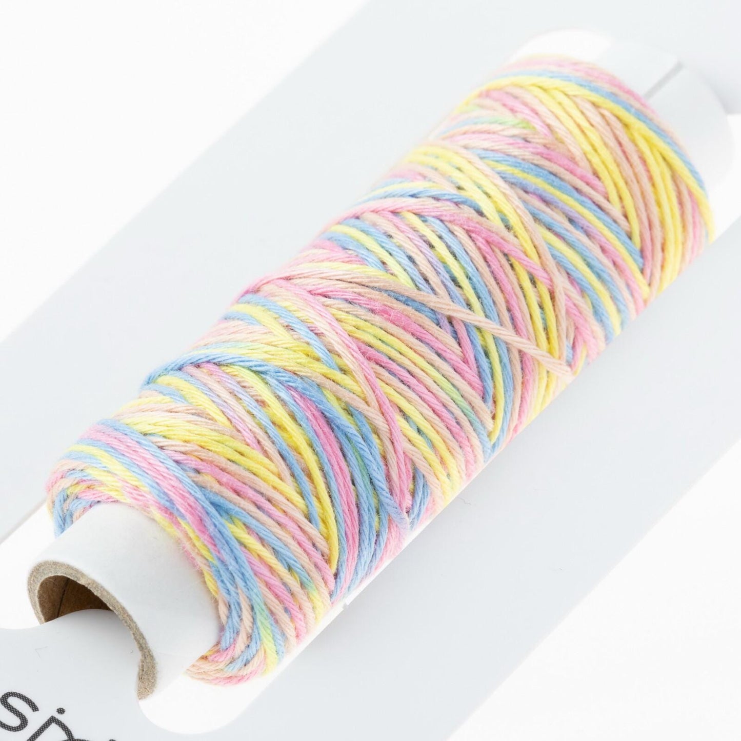 A spool of multicolored thread is shown, with the thread winding around the spool and creating a colorful, tangled pattern.
