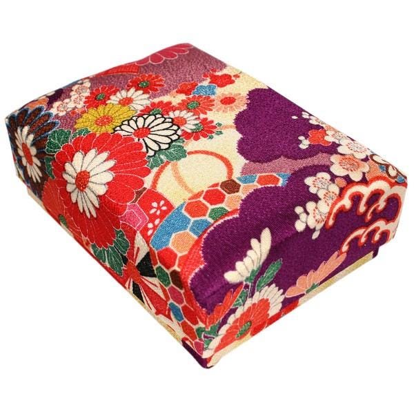 a colorful, intricately designed box with a floral pattern in shades of red, purple, and white.