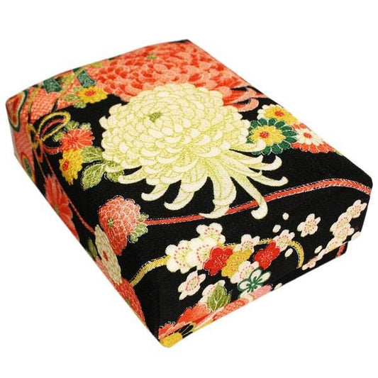 a box with a floral pattern on it, including a large white flower and smaller flowers in various colors.
