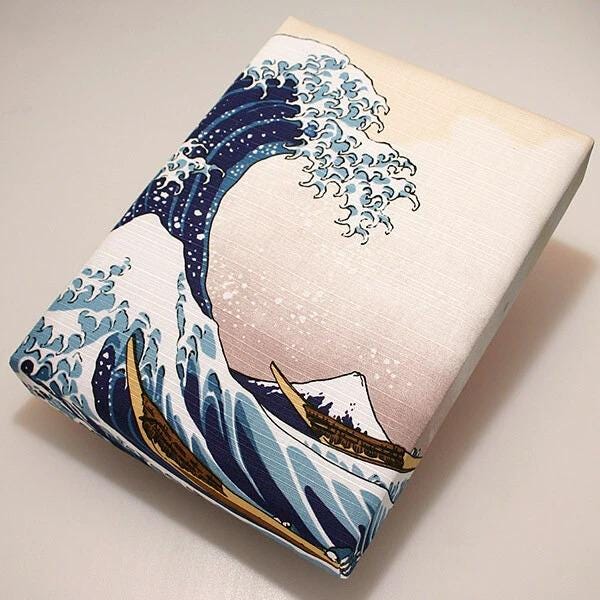 a large, colorful painting of a wave with a boat in the foreground.