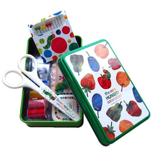 A green tin box with a pattern of colorful fruits and vegetables, including strawberries, apples, and oranges, along with a pair of scissors.