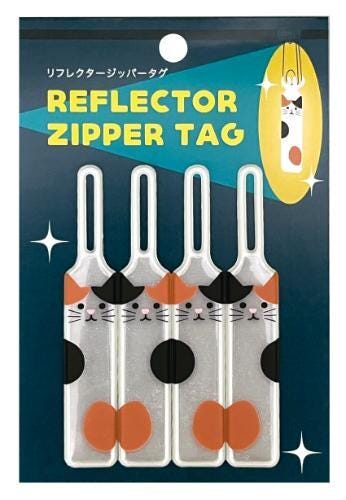 A package of four zippers with cat faces printed on them, designed to be used as zipper tags.