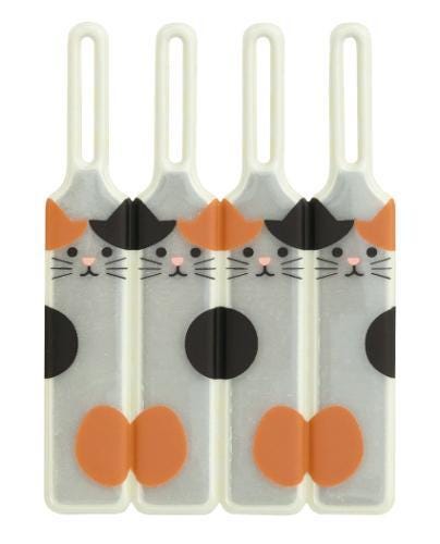 4 white and orange cat-shaped tags with black whiskers and paws.