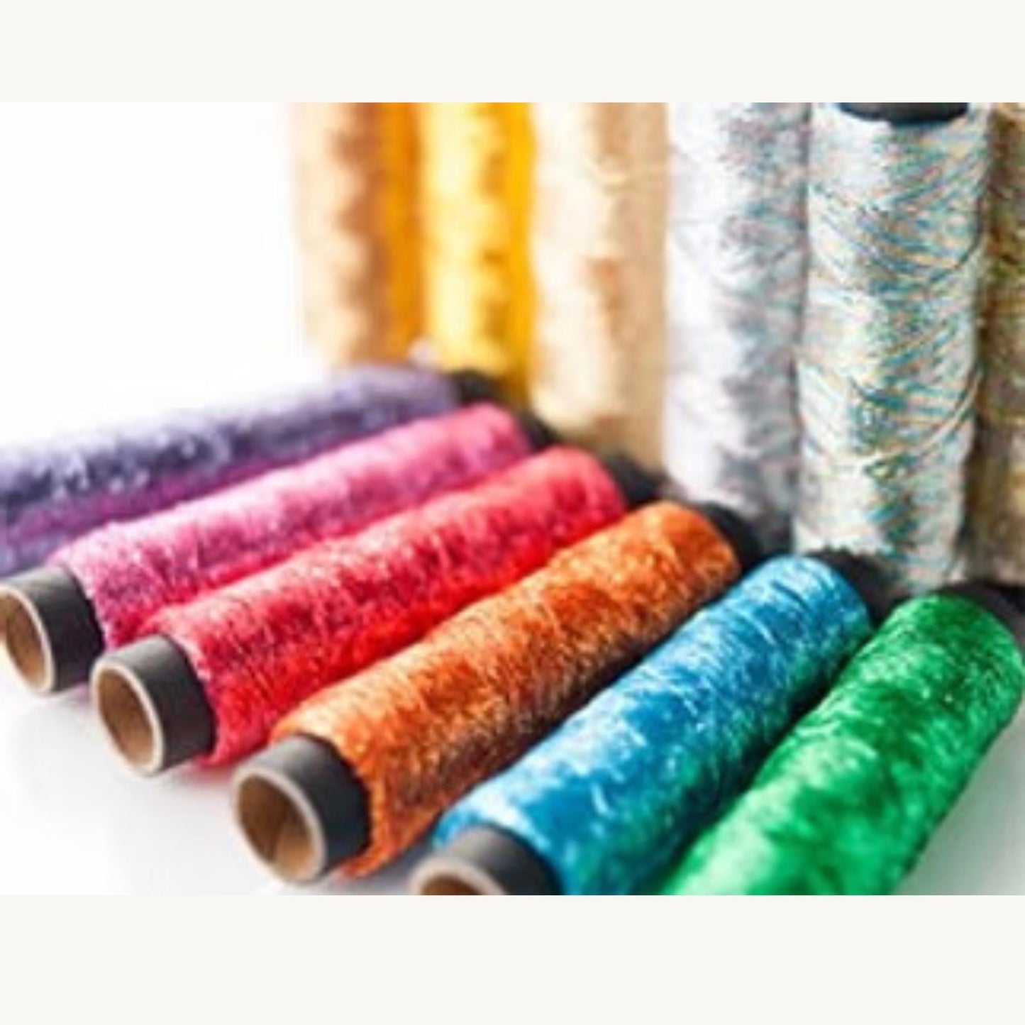 A collection of colorful spools of thread or yarn, with various colors and patterns, arranged in a row.
