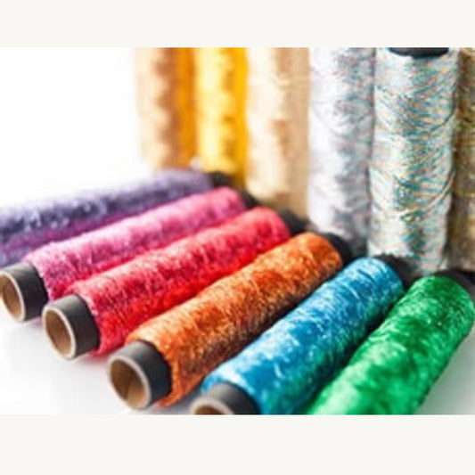 A collection of colorful spools of thread or yarn, with various colors and patterns, arranged in a row.