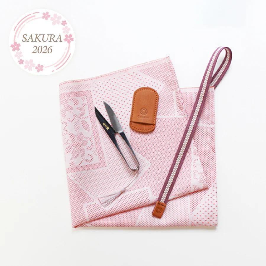 a pink and white patterned cloth, a pair of scissors, a leather pouch, and a zipper pouch, all arranged on a white background.