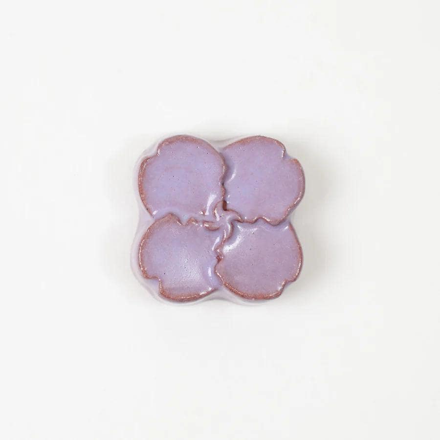 A single purple flower-shaped object is centered against a white background.