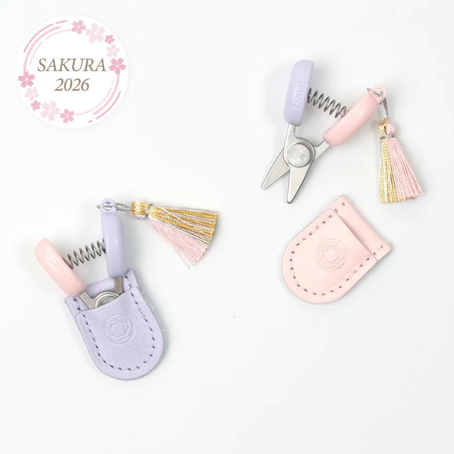 a pair of scissors with tassels and a keychain, all placed on a white background.