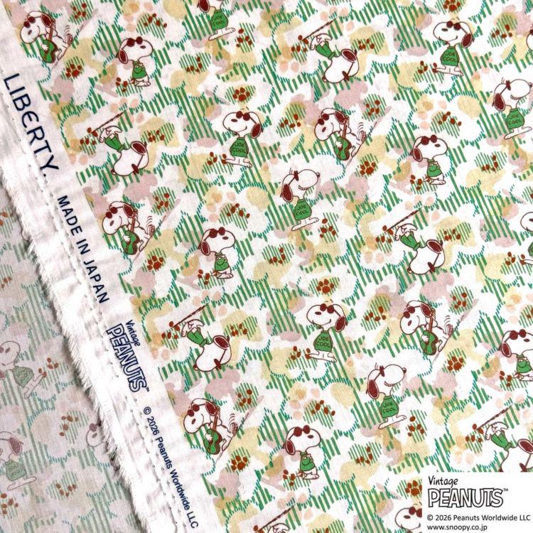 a fabric with a repeating pattern of cartoon characters, specifically the Peanuts characters, in various colors and poses.