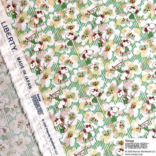 a fabric with a repeating pattern of cartoon characters, specifically the Peanuts characters, in various colors and poses.
