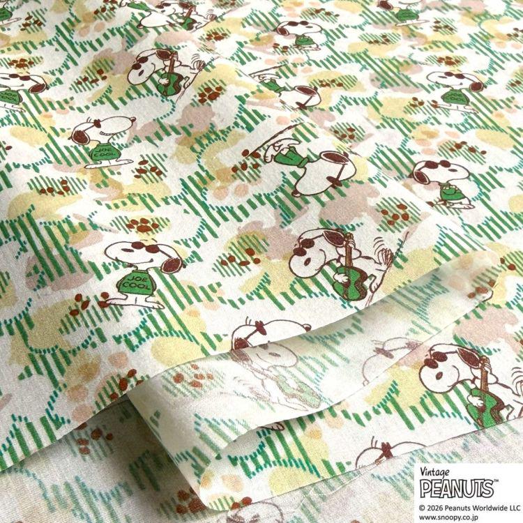 a repeating pattern of cartoon characters, specifically the Peanuts characters, on a fabric or paper.