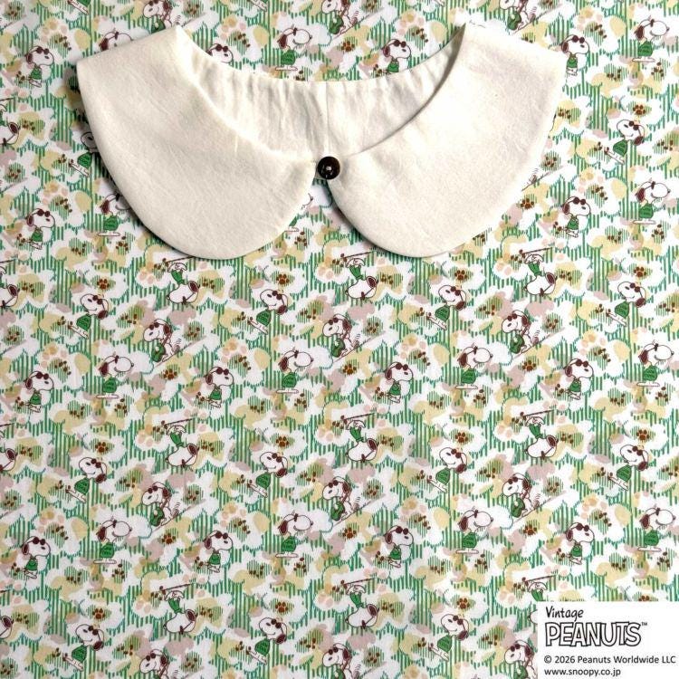 A white collar is displayed against a floral print background.