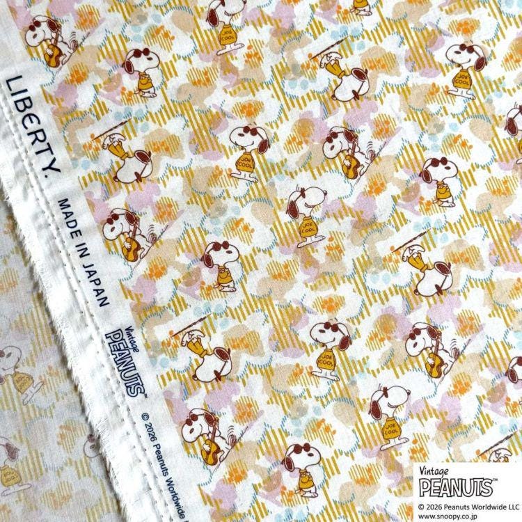 a fabric with a repeating pattern of cartoon characters, specifically the Peanuts characters, in various poses and colors.