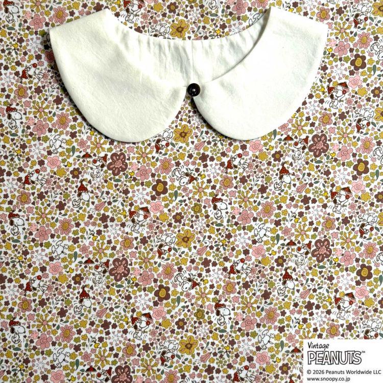 A white collar is placed on a floral print background.