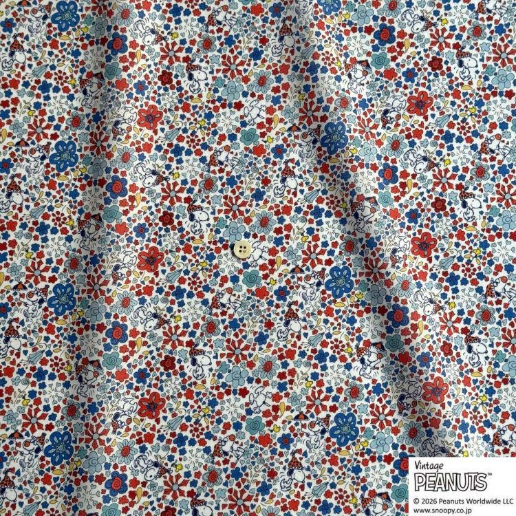 The image is a close-up of a fabric with a vibrant floral pattern in various colors, including red, blue, and white. The pattern features small flowers and leaves, creating a lively and colorful appearance.