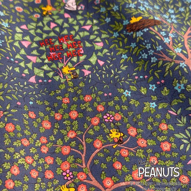 a close-up view of a colorful fabric with a floral pattern and various cartoon characters, including Snoopy, Peanuts, and Peanuts.