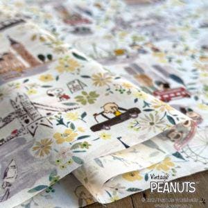 The image is a close-up of a fabric with a floral pattern, featuring various cartoon-like illustrations such as a car, a person, and other whimsical elements.