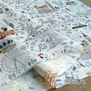 The image is a close-up of a fabric with a pattern of various cartoon characters and landmarks, including a ferris wheel, buildings, and other iconic elements.