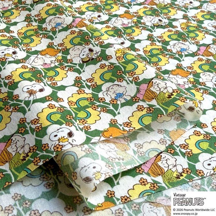 a repeating pattern of cartoon characters, including Snoopy, on a fabric with a floral and cloud-like design.