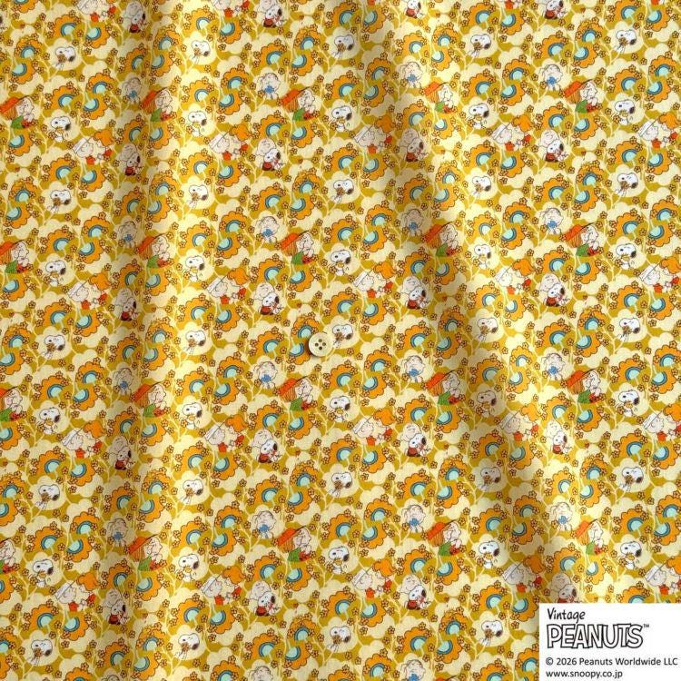 The image is a fabric with a repeating pattern of cartoon characters, including a dog, a cat, and a bird, in various colors such as yellow, orange, and blue.
