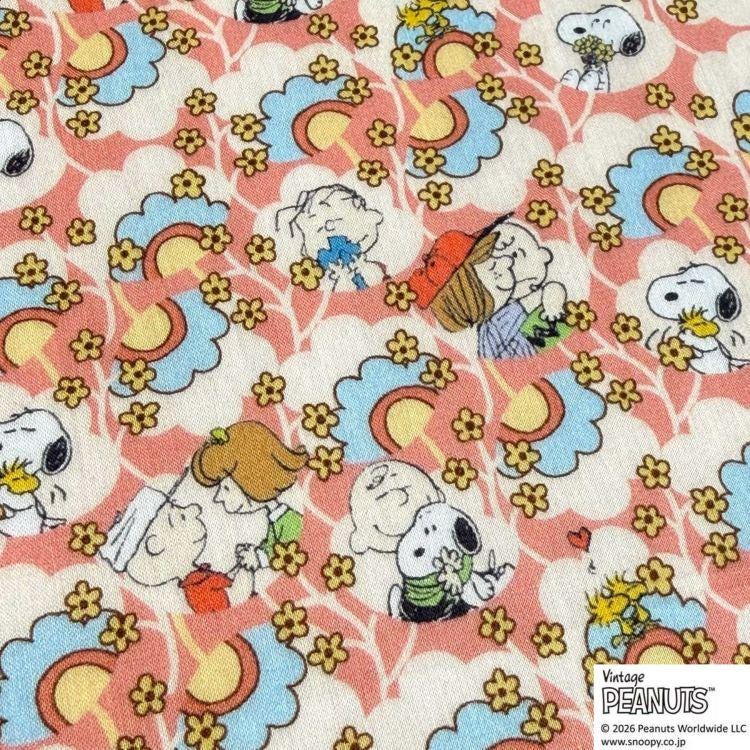 The image is a collage of various Peanuts characters, including Snoopy, Charlie Brown, and Woodstock, all set against a background of colorful flowers and clouds.