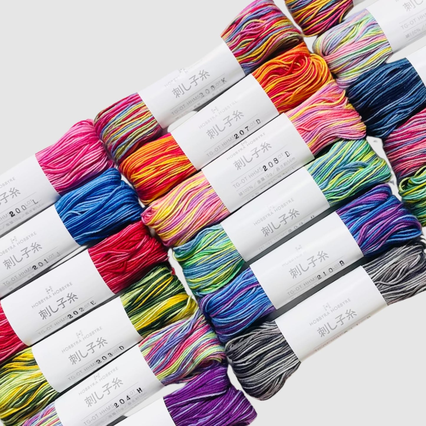 a collection of colorful yarn skeins arranged in rows, with each skein having a label that includes Japanese text.