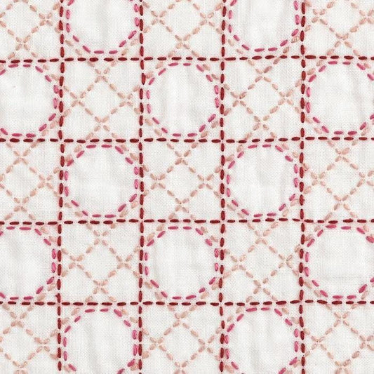 a close-up view of a fabric with a repeating pattern of pink and white circles and lines, creating a visually striking and intricate design.