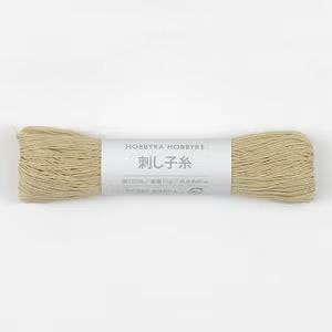 A spool of beige yarn with a label that reads "Hobbyra Hobby" and "100% Pure Cotton Yarn" in Japanese.