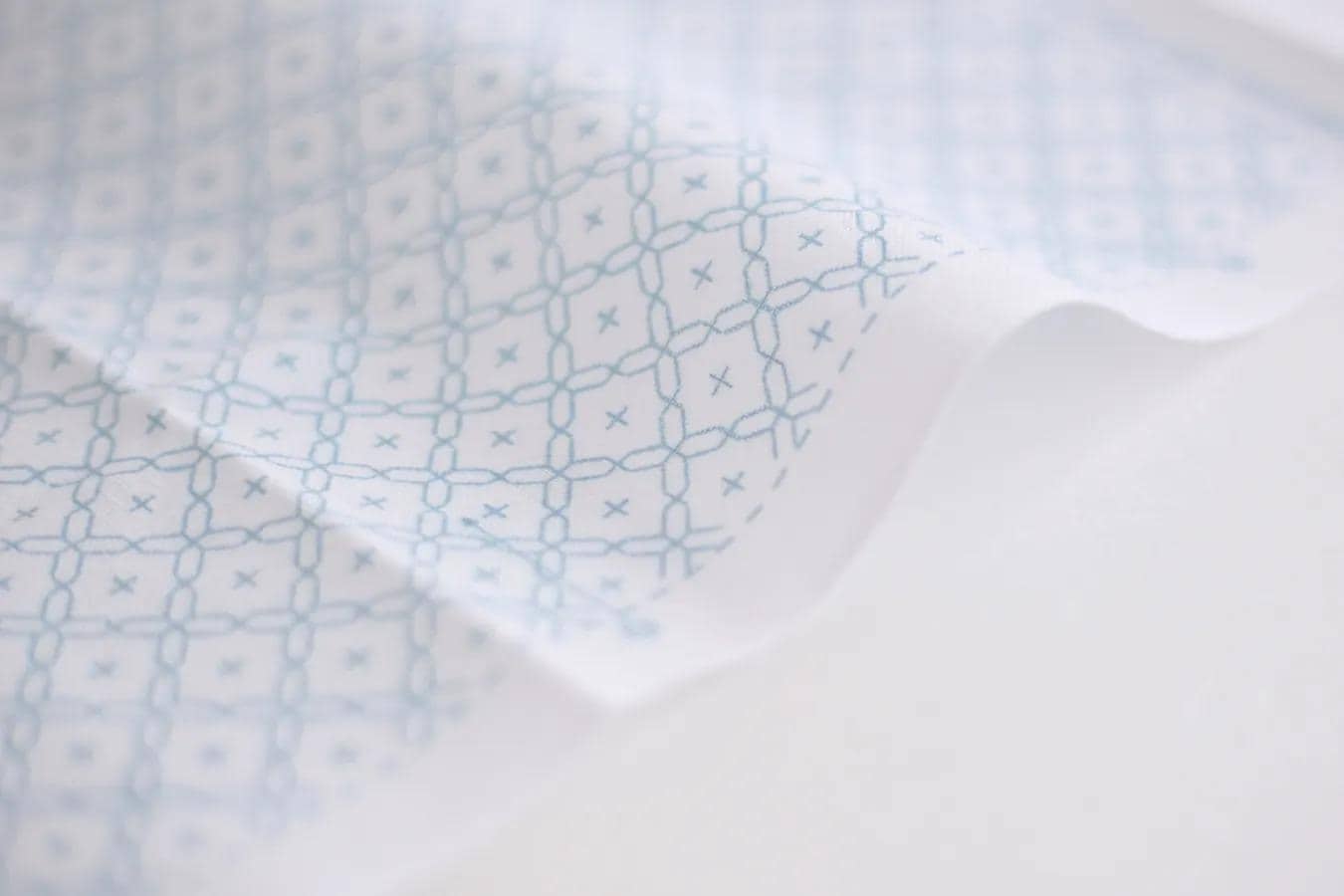 a close-up view of a fabric with a repeating pattern of blue and white geometric shapes, creating a visually interesting and textured surface.