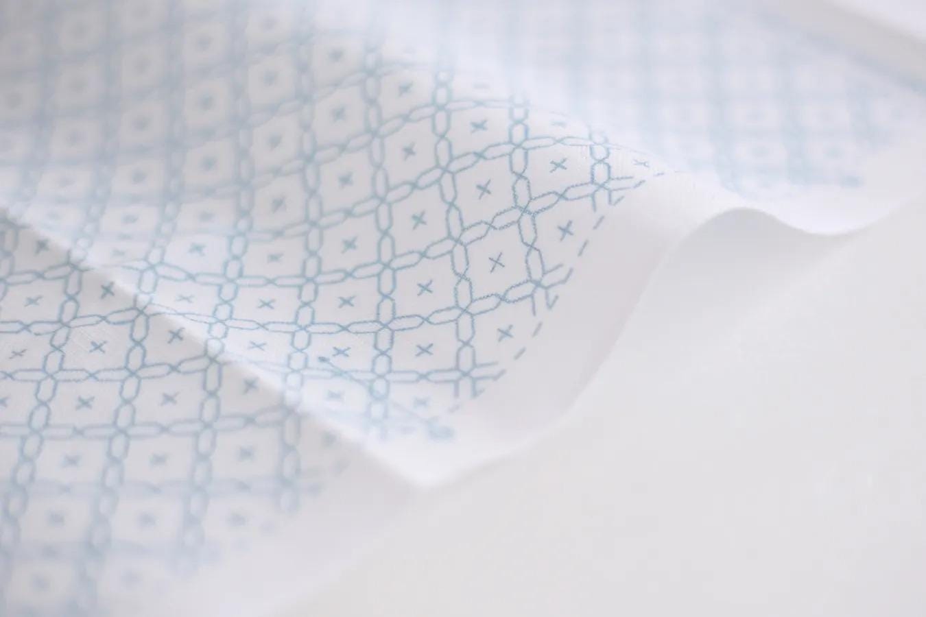 a close-up view of a fabric with a repeating pattern of blue and white geometric shapes, creating a visually interesting and textured surface.