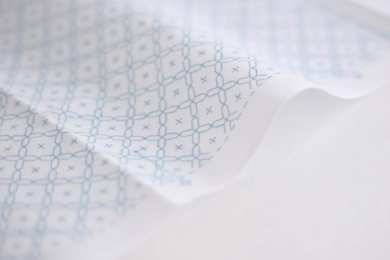 a close-up view of a fabric with a repeating pattern of blue and white geometric shapes, creating a visually interesting and textured surface.