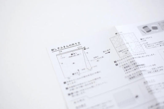 The image is a close-up of a printed document with Japanese text, including diagrams and bullet points. The text appears to be in Japanese and is not in English. The document is not in English, and there are no other visible texts or objects in the image.