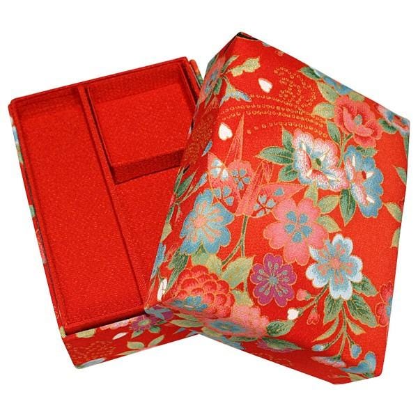 a red box with a floral pattern, featuring a red and blue design with flowers and leaves.